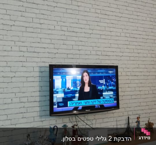 קיר לבנים לבן עם טלוויזיה תלויה